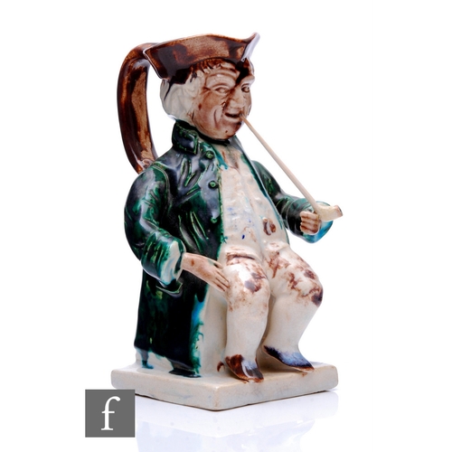 221 - An early 19th Century Toby jug modelled as a seated gentleman in tricorn hat, frock coat, waistcoat ... 