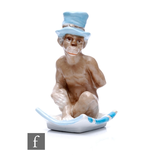 247 - A 19th Century continental hard paste porcelain chamber stick modelled as a seated monkey wearing a ... 