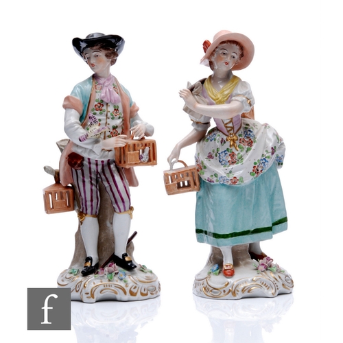 135 - A pair of 20th Century Sitzendorf figures of bird sellers in floral decorated period costume, underg... 