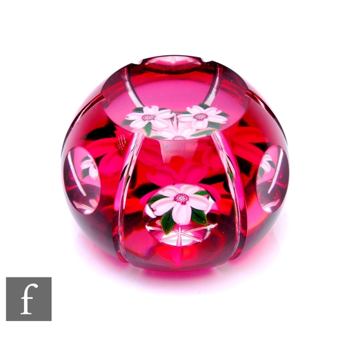 586 - A later 20th Century John Deacons glass paperweight, of domed form, cased in ruby over clear and fla... 