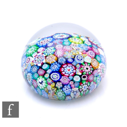 608 - A contemporary John Deacons glass paperweight, of domed form, internally decorated with close pack m... 