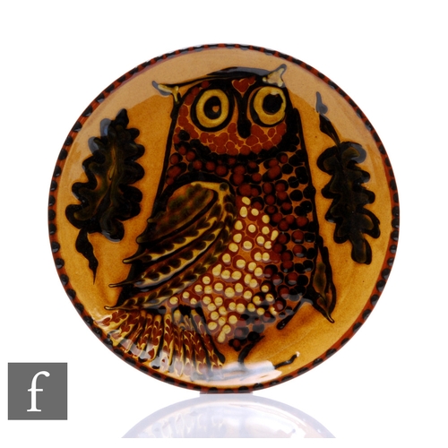 287 - A later 20th Century slip ware dish, the shallow circular well slip decorated with a stylised owl wi... 