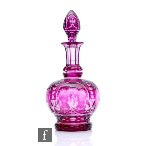 398 - A 20th Century decanter of footed globe and shaft form with a spire form stopper, cased in amethyst ... 