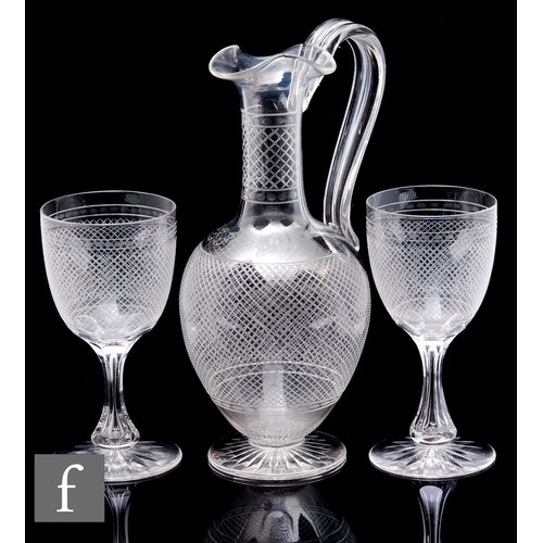 425 - An Edwardian clear crystal claret jug with fine engraved linear decoration with high loop handle, he... 