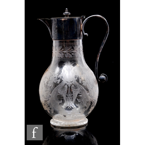 455 - A late 19th Century clear crystal claret jug engraved with winged griffins and foliate scrolls below... 