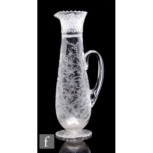 469 - A late 19th Century clear crystal water jug of slender tapered sleeve form with a wrythen body and a... 