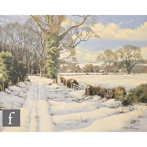 923 - TONY WOODING (BORN 1969) - A country lane under snow, a distant church beyond, oil on canvas, signed... 