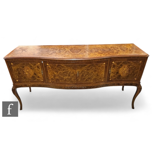 1002 - A 20th Century Italian figured walnut dining room suite, comprising a serpentine front sideboard on ... 