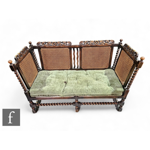 1012 - A 1920s three seater bergere style settee, single cane side, on spiral block legs, width 146cm.