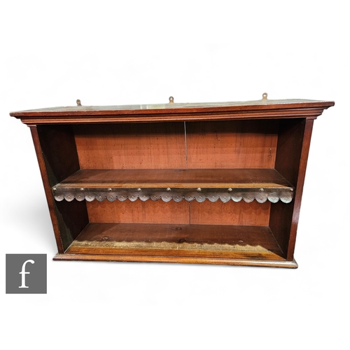 1044 - An Edwardian mahogany bookcase of narrow proportions enclosed by a pair of bar glazed doors below a ... 