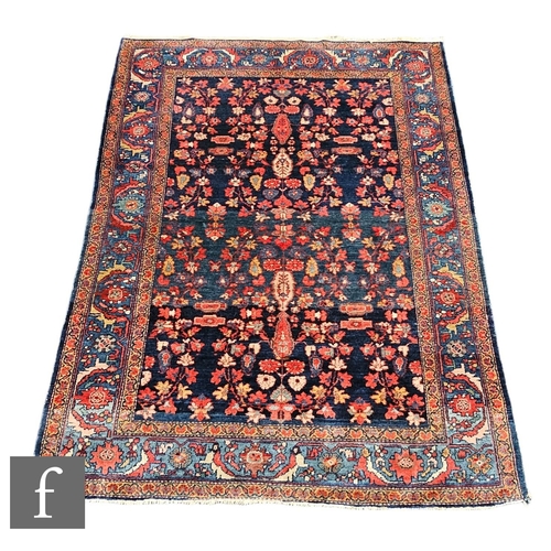 1072 - A Sarouk rug, all over floral design on a deep blue ground within a running leaf multi border, 200cm... 