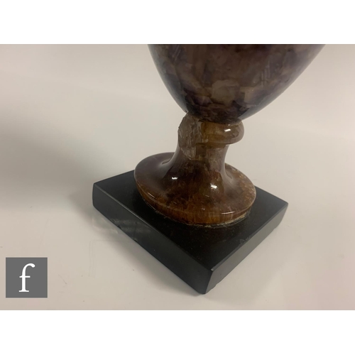 798 - A 19th Century Blue John vase of urn shape, with fixed cover and turned pedestal base, on a slate sq... 