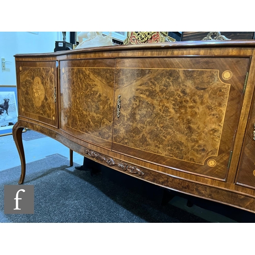 1002 - A 20th Century Italian figured walnut dining room suite, comprising a serpentine front sideboard on ... 