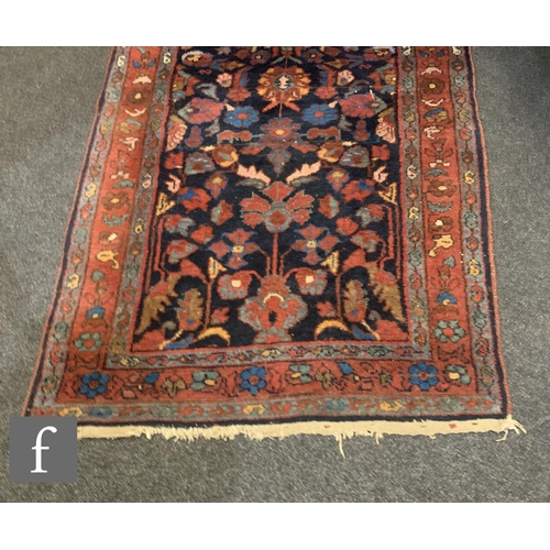 1073 - A Hamadan runner, all over floral design on a deep blue ground within multi flower head border, 296c... 