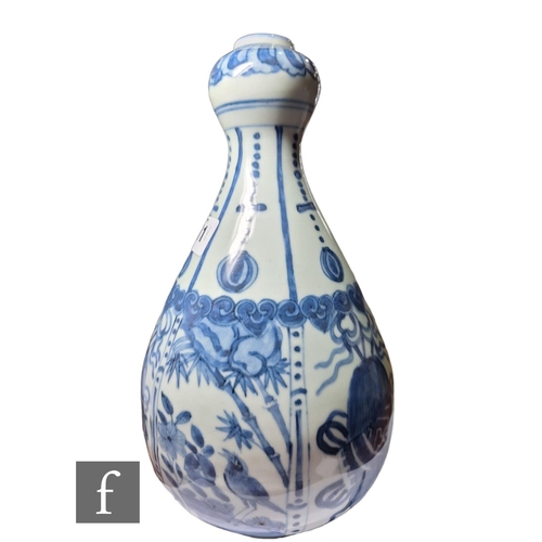 11 - A Chinese Wanli style blue and white garlic head vase, decorated with segmented panel, filled with b... 