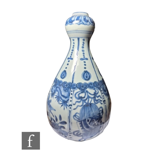 11 - A Chinese Wanli style blue and white garlic head vase, decorated with segmented panel, filled with b... 