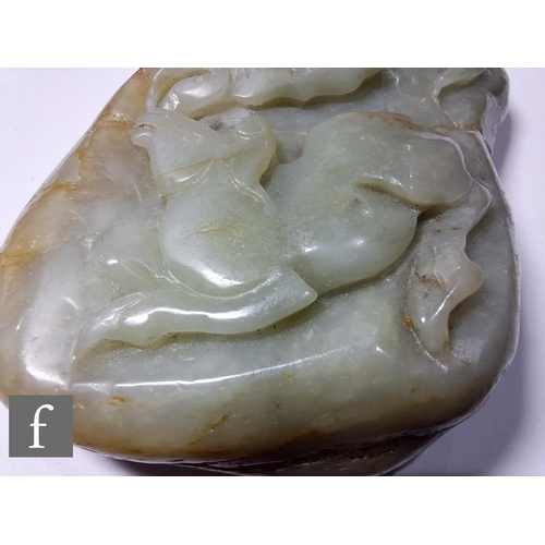 14 - A Chinese Qing Dynasty jade pebble carving, the smooth pale green and russet stone, carved in relief... 