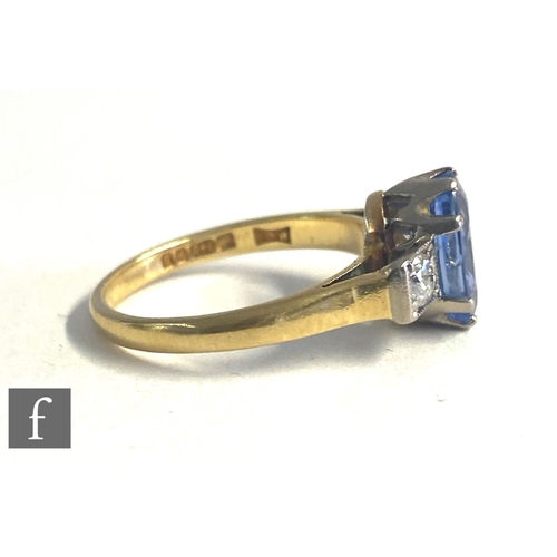 72 - An 18ct hallmarked sapphire and diamond three stone ring, central oval cornflower blue sapphire flan... 