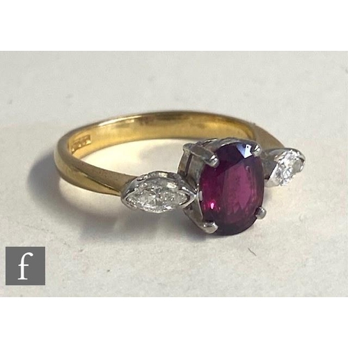 74 - An 18ct hallmarked ruby and diamond three stone ring, central oval ruby, length 7mm, flanked by a ma... 