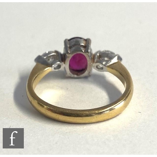 74 - An 18ct hallmarked ruby and diamond three stone ring, central oval ruby, length 7mm, flanked by a ma... 