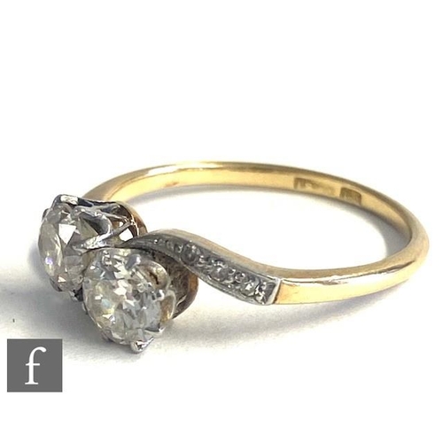 82 - An early 20th Century 18ct diamond two stone cross over ring, claw set stones, each approximately 0.... 