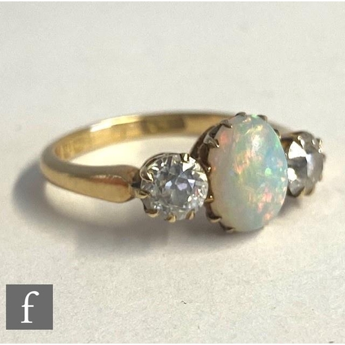 83 - An 18ct opal and diamond three stone ring, central oval opal, length 9mm, flanked by a 0.40ct diamon... 