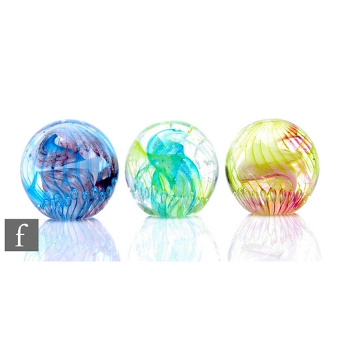 836 - Three contemporary Isle of Wight studio glass paperweights of domed form, all internally decorated w... 