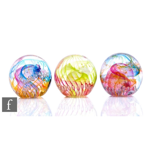 839 - Three contemporary Isle of Wight studio glass paperweights of domed form, all internally decorated w... 