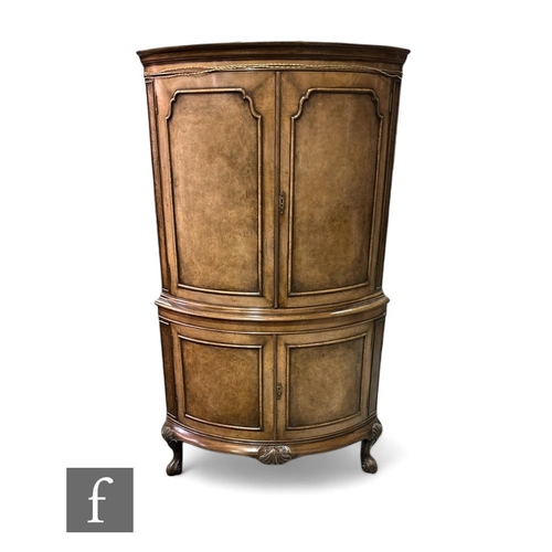 392 - A Queen Anne style walnut floorstanding cocktail cabinet, the mirrored interior enclosed by shaped b... 