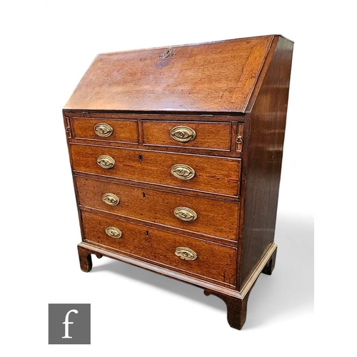 412 - A George III oak country bureau, the fitted drawer and pigeon hole interior enclosed by a fall over ... 