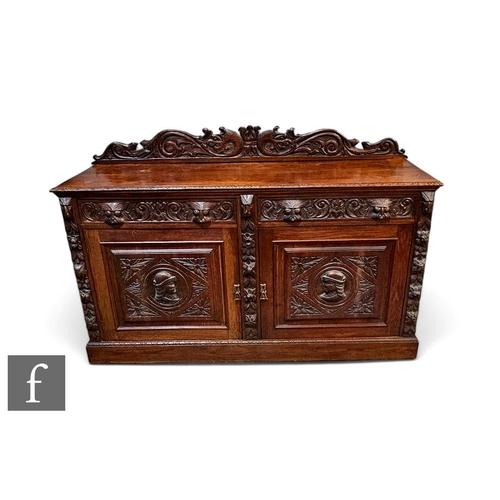 415 - A Victorian carved oak sideboard fitted with two drawers over a panelled cupboard plinth base, mask ... 