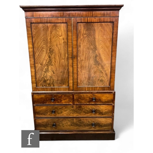 433 - A 19th Century mahogany and flame mahogany linen press, the double door revealing five fitted pull o... 