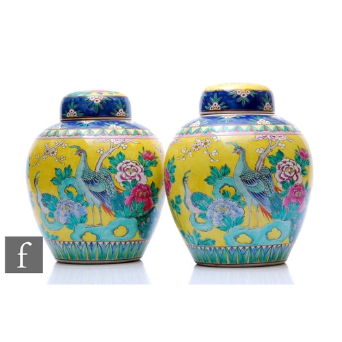 67 - A pair of 20th Century yellow ground Chinese famille rose jars and covers, of rounded ovoid form app... 