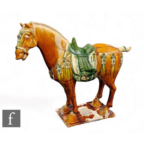 72 - A Chinese Tang Dynasty style horse, of typical form, modelled in standing position with ochre and gr... 