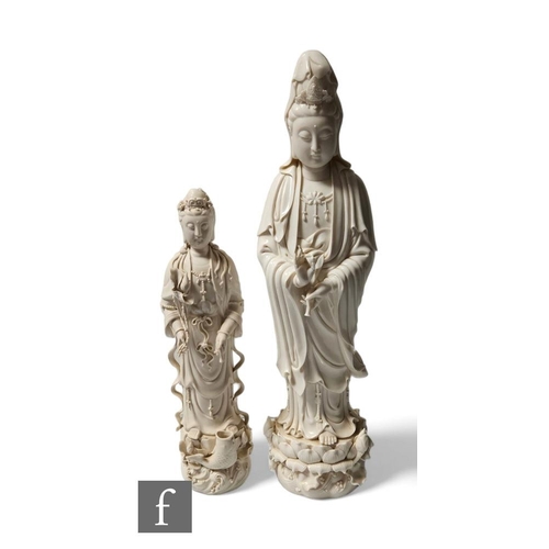 74 - Two Chinese Blanc-de-chine figures of Guanyin, both in standing position, raised on lotus base, each... 