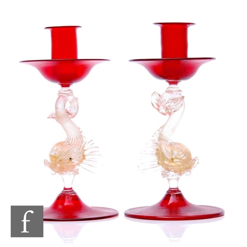 768 - A pair of 20th Century Italian Murano glass candlesticks in the manner of Savliati, the deep red sco... 