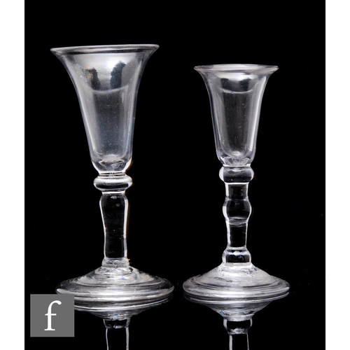 An 18th Century baluster Gin glass circa 1740, the tall drawn bell form bowl above a compressed upper knop and plain stem with small basal knop, raised to a folded conical foot, height 12cm, together with a similar smaller example with bello form bowl above a triple knopped stem and folded conical foot, height 10.5cm. (2)