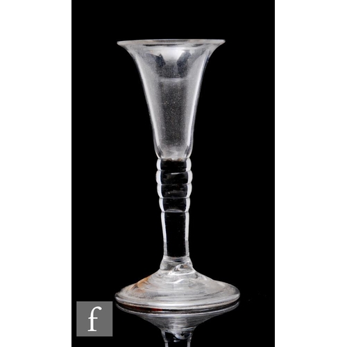 878 - An 18th Century baluster gin glass circa 1740, the slender drawn trumpet bowl above a bobbin type st... 