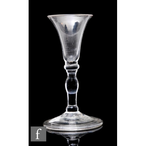 884 - An 18th Century baluster gin glass, the flared trumpet bowel above an upper compressed knop, invert ... 