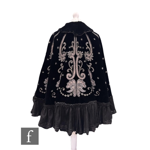 55 - A late 19th Century black velvet evening cape, decorated with bead and grey silk foliate scroll belo... 