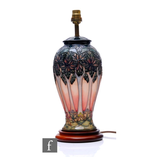 541 - A Moorcroft pottery Cluny pattern table lamp, raised on a wooden base, height 30cm.