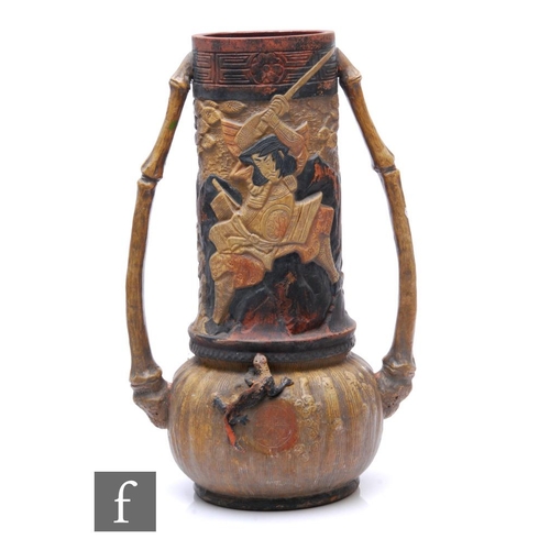 561 - A large Bretby 'Japanese' vase, flanked by bamboo handles, relief moulded with depictions of samurai... 