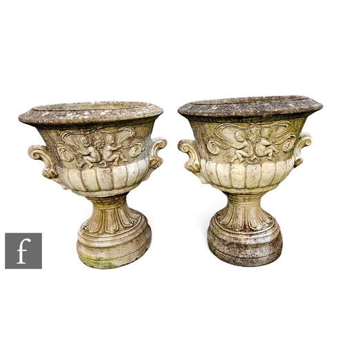 399A - A large pair of reconstituted stone garden urns, each of pedestal form relief cast with putti, overa... 