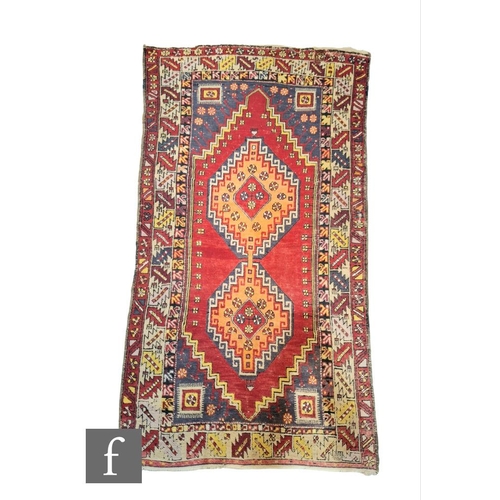 369 - A Turkish Ortakoy woven wool rug, circa 1960, the red ground rug with central diamond lozenge, with ... 