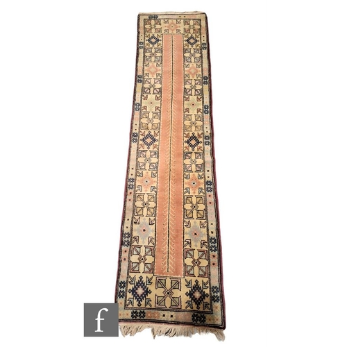 373 - A Turkish Oushak runner, the ochre and pink ground runner with tasselled fringing and central geomet... 