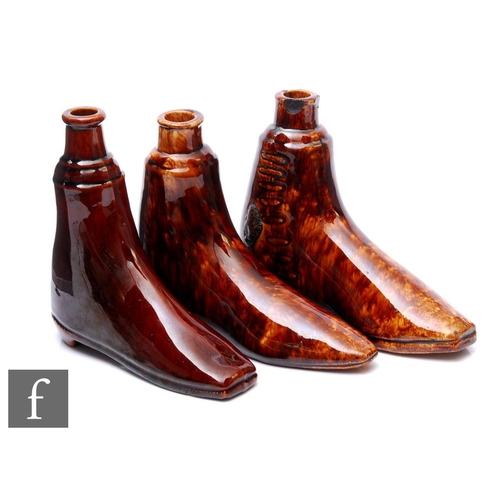 499 - A collection of three 19th Century novelty drinking flasks modelled as boots, with all over treacle ... 