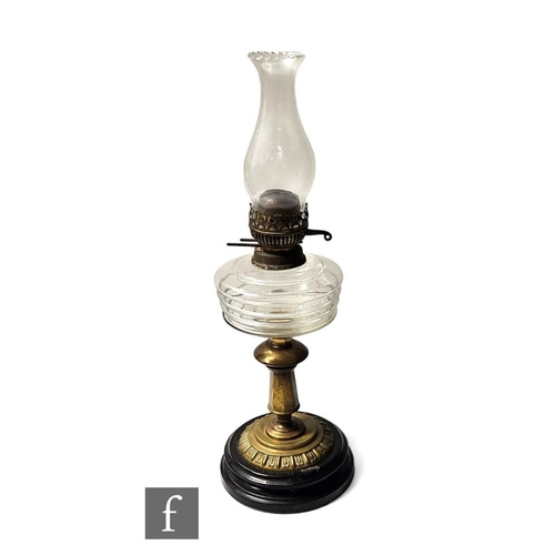 904 - A late 19th Century oil lamp, the clear turned black marble base with brass stem and clear crystal f... 