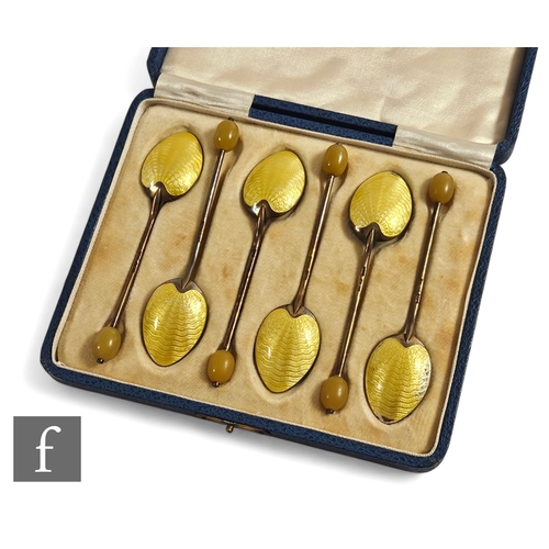 16 - A cased set of six hallmarked silver coffee bean spoons each with yellow enamel decoration to bowl r... 