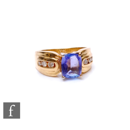 126 - A 14ct tanzanite and diamond ring, central cushioned emerald cut tanzanite, length 8mm, flanked by t... 