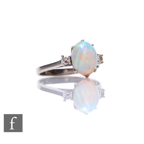 129 - An 18ct hallmarked white gold opal and diamond three stone ring, central oval opal, length 10mm, fla... 